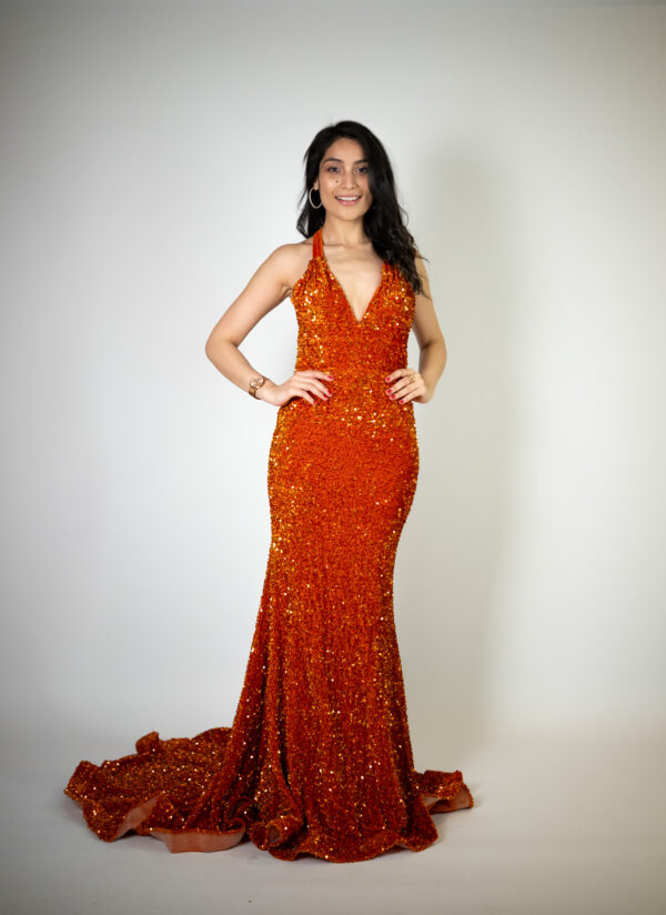 Alt text: "Burnt orange velvet and sequin gown called Kozeta, featuring an open cross low back, mermaid flare, and ruched detailing, perfect for glamorous occasions. Size fits: 4-6."