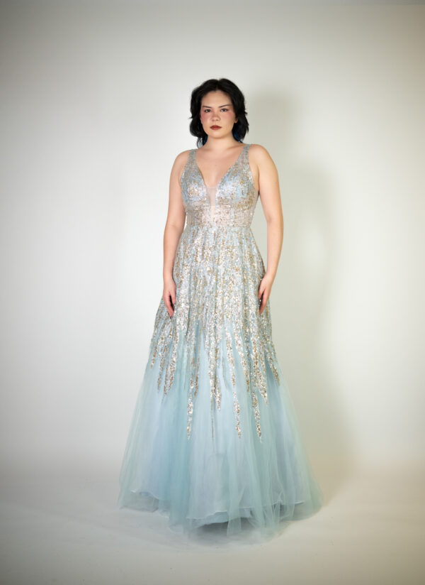 Alt text: "Light blue princess gown called Senka, featuring mesh panels with glitter and sequin patterns and a low V cut back, perfect for glamorous occasions."