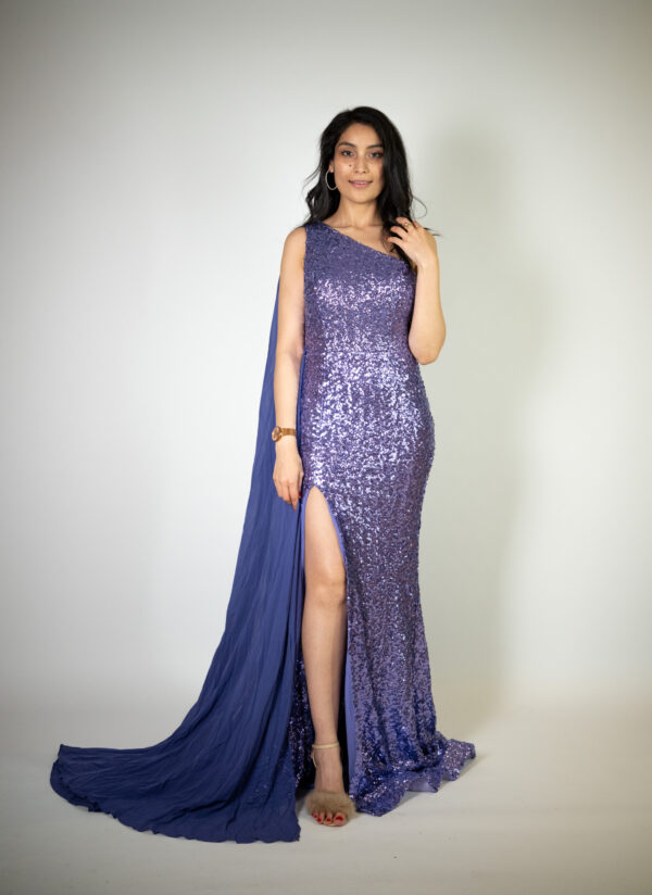 Alt text: "Bright purple gown called Ube, featuring a one-shoulder cape, high slit, full sequins, and a mid-length train, perfect for glamorous occasions."