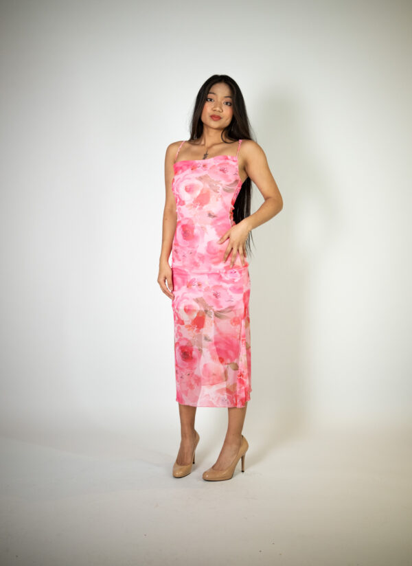 Alt text: "Baby pink maxi dress called Rosa, featuring a mini dress underlayer and a sheer outer layer adorned with roses, perfect for summer occasions."