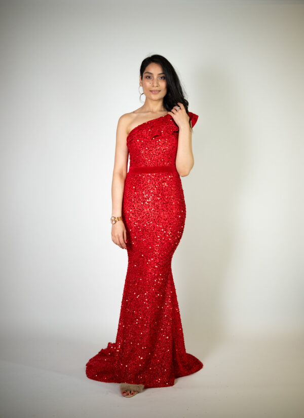 Alt text: "Red sequin-covered gown called Goose, featuring a one-shoulder design and satin belt, perfect for special occasions."