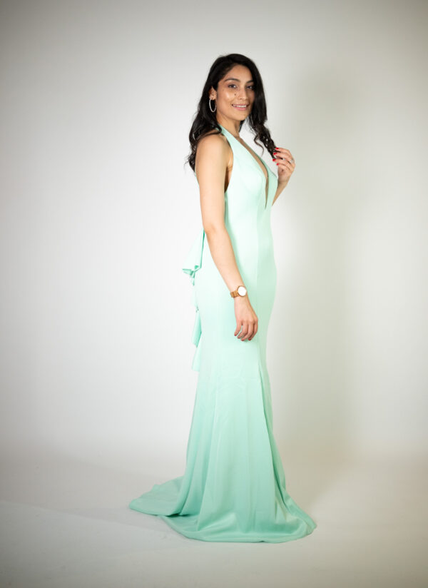 Alt text: "Tiffany blue V-neck gown called Susie, featuring an open back, glitter pattern, and ruffles, perfect for glamorous occasions. Size fits: 4-6."