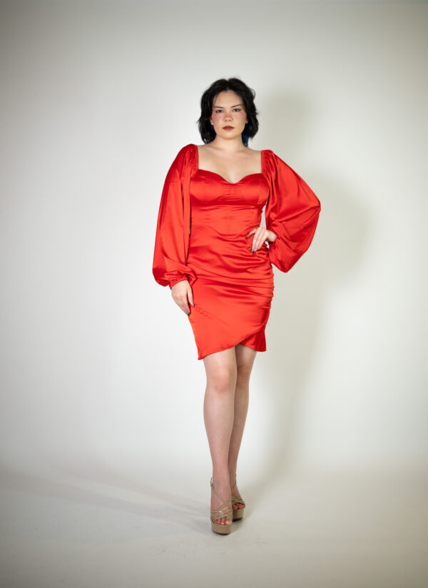 Alt text: "Red mini dress called Terk, featuring a bustier and poofy silk sleeves, perfect for special occasions."