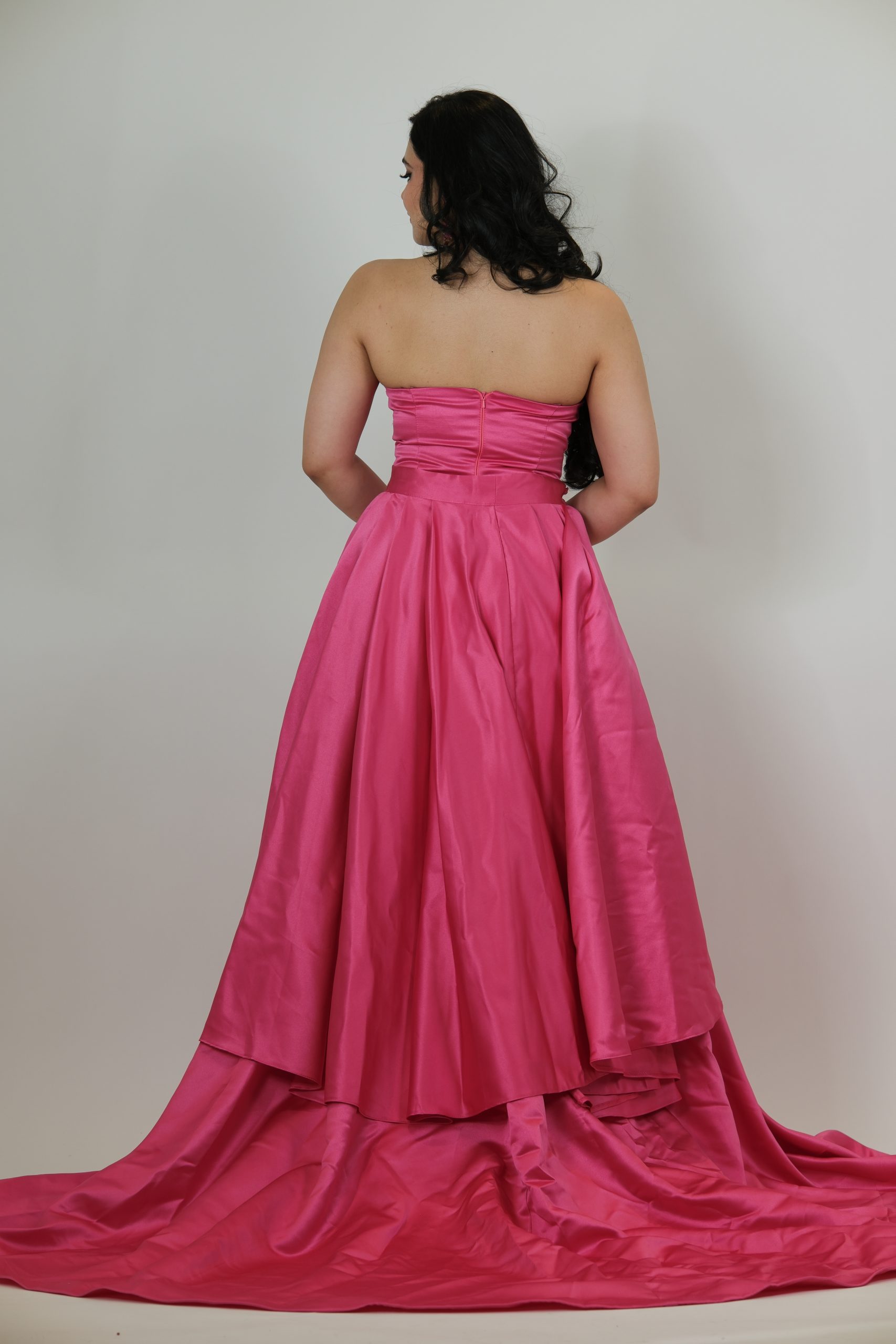 “Fuchsia strapless gown with beaded sweetheart bodice and satin skirt with a dramatic detachable overskirt.”