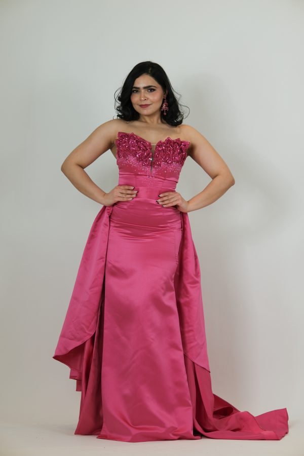 “Fuchsia strapless gown with beaded sweetheart bodice and satin skirt with a dramatic detachable overskirt.”