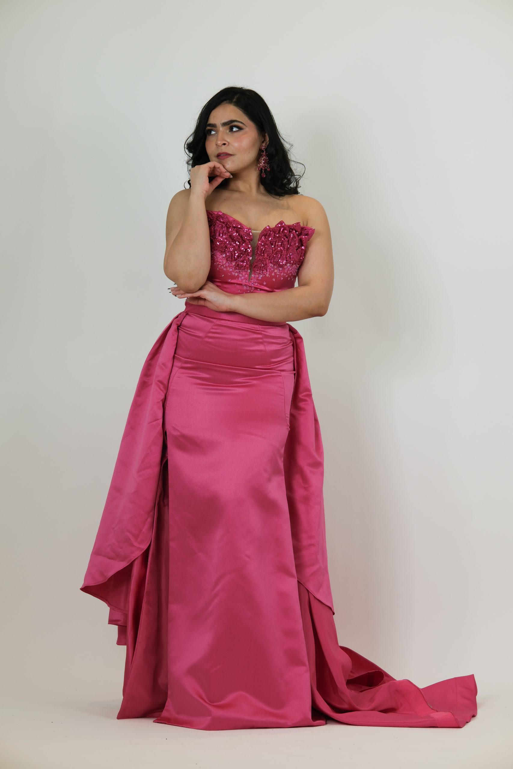“Fuchsia strapless gown with beaded sweetheart bodice and satin skirt with a dramatic detachable overskirt.”