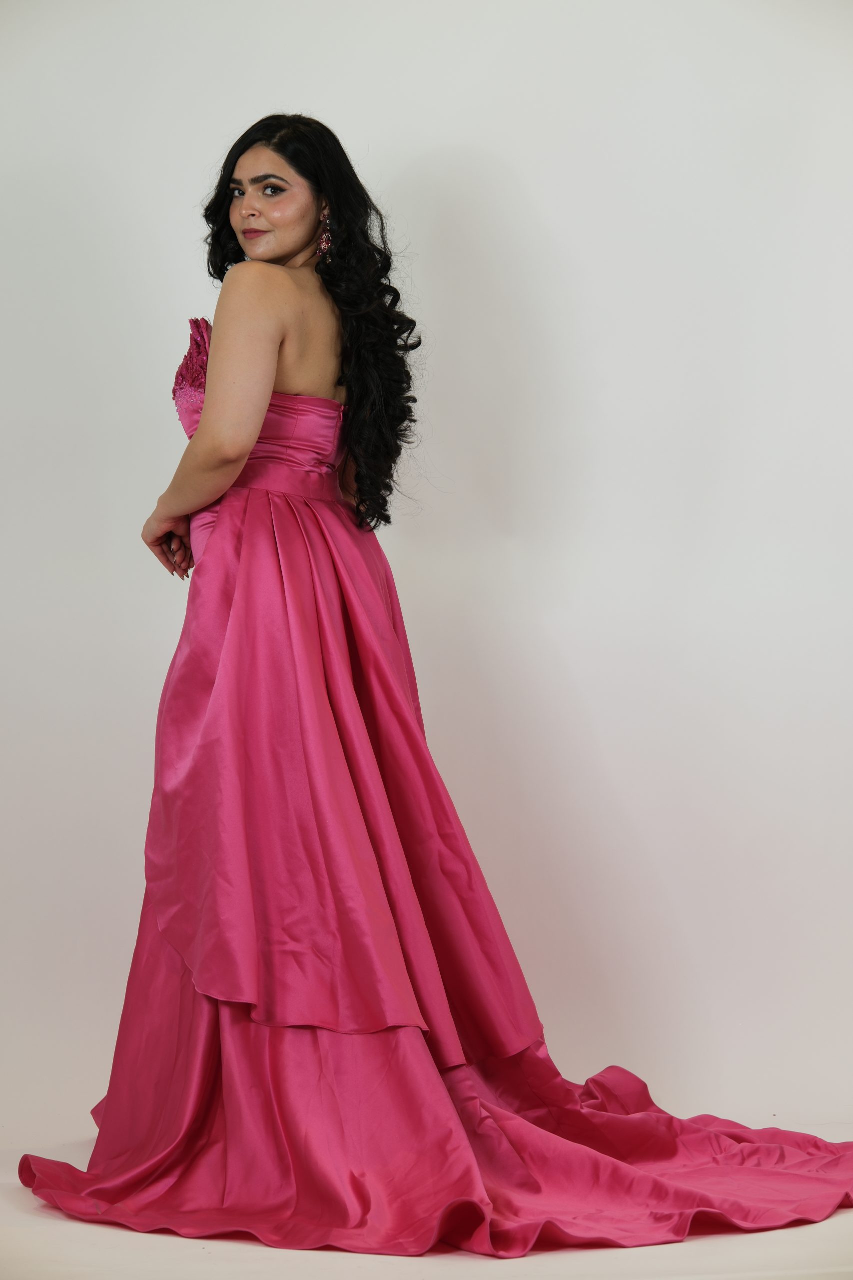 “Fuchsia strapless gown with beaded sweetheart bodice and satin skirt with a dramatic detachable overskirt.”