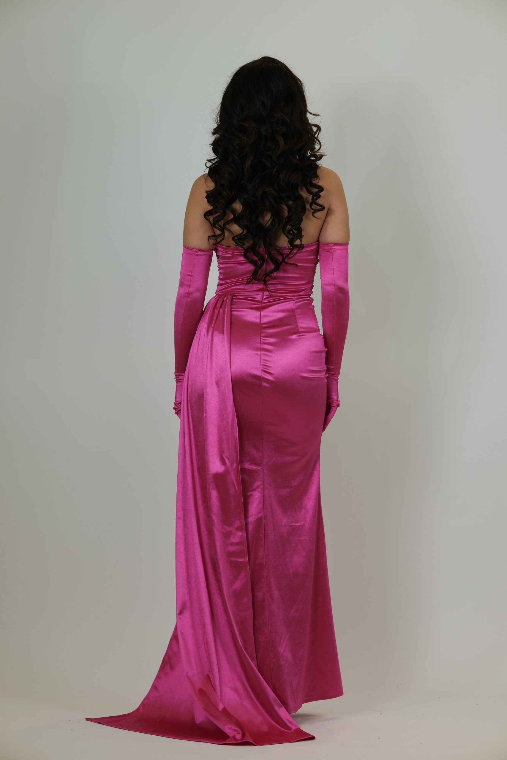 "Hot pink satin evening gown called Calanthe, featuring a strapless draped bodice, high slit, ruched waist, and matching long glove