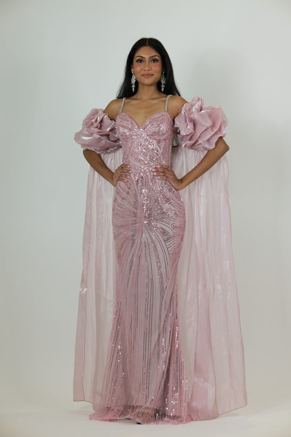 “Blush pink sequin gown with diamond straps, dramatic puff sleeves, and a long glossy cape.”