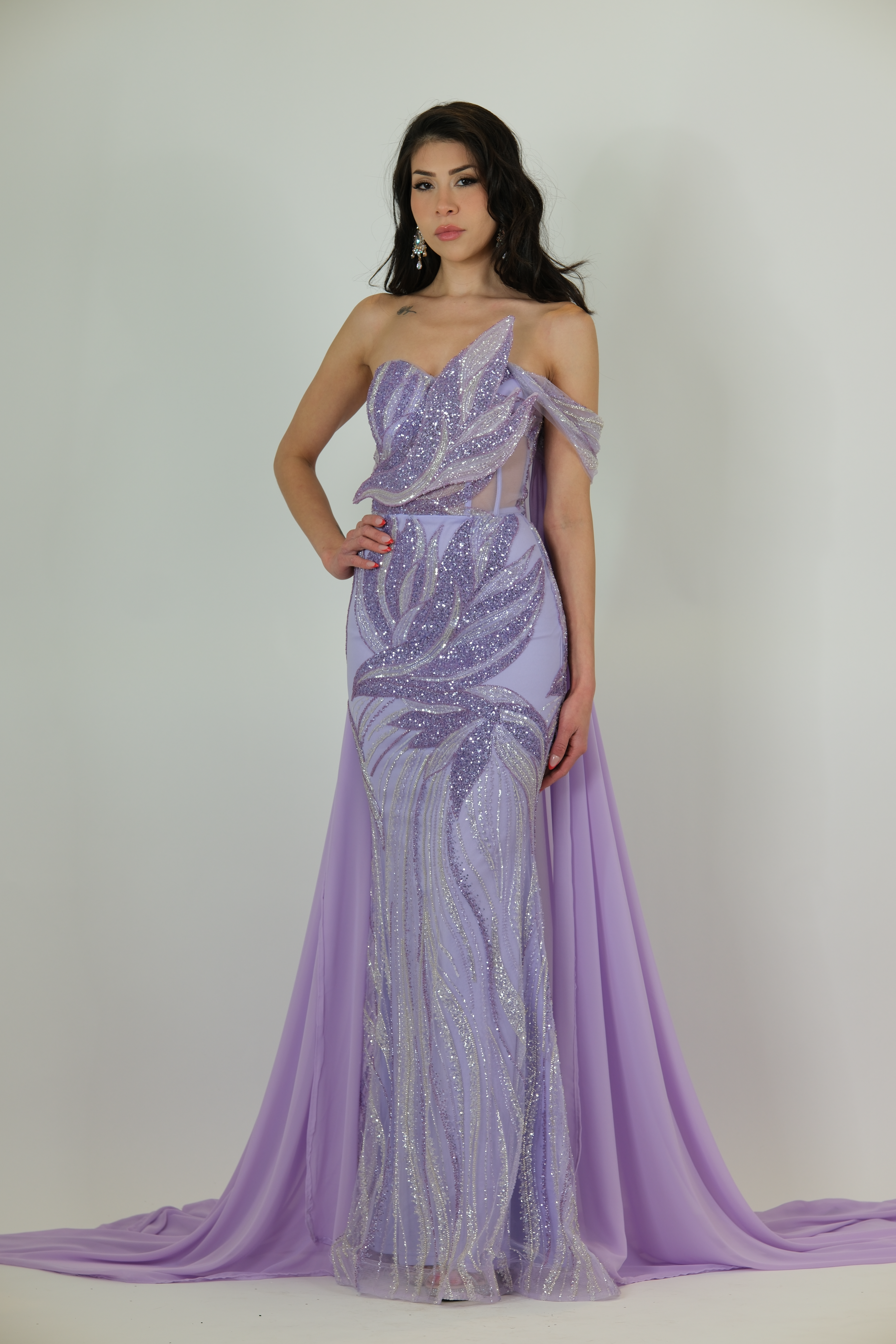 “Lilac sequin evening gown with off-shoulder applique detailing, sheer side panels, fitted skirt, and optional detachable chiffon cape.”