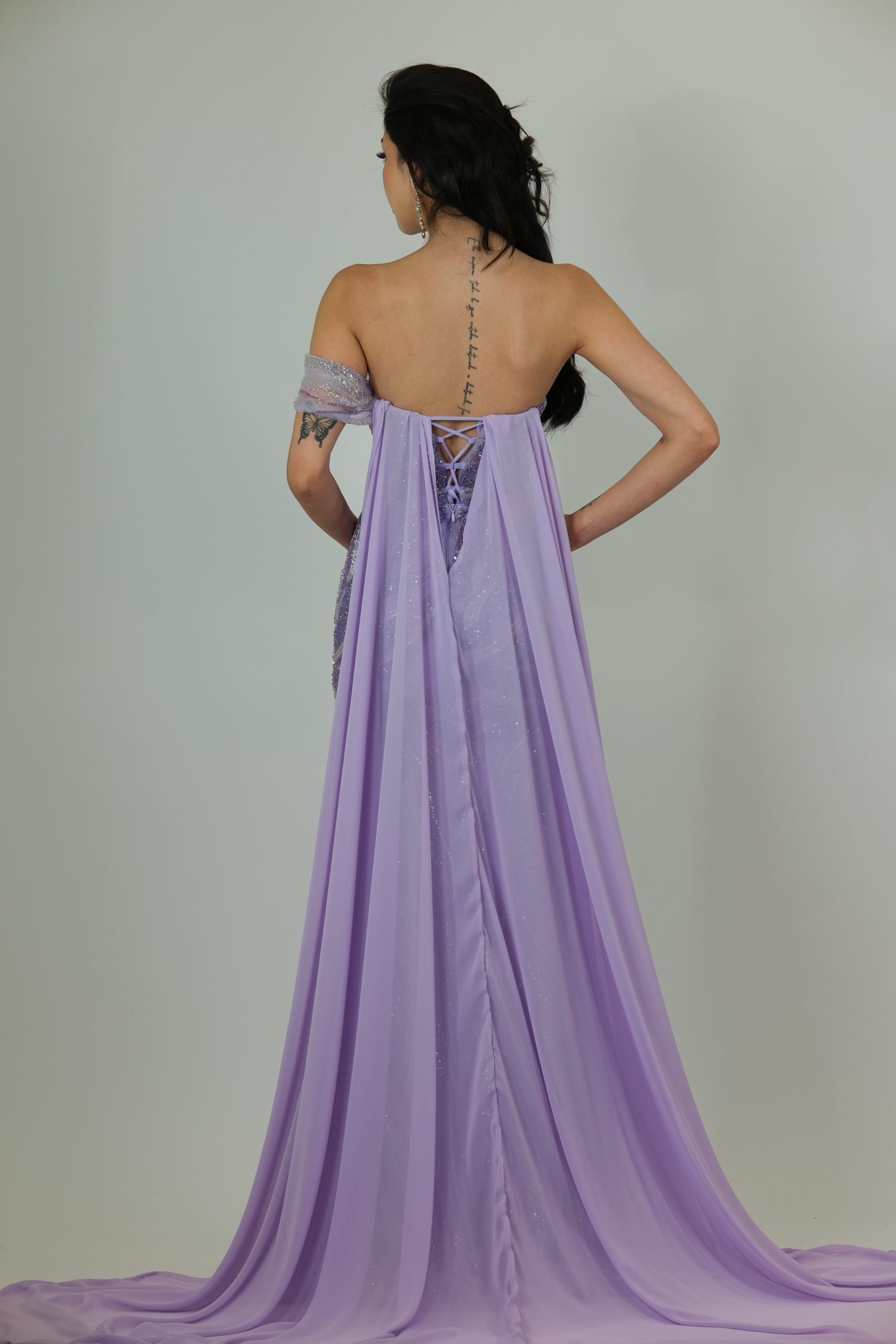 “Lilac sequin evening gown with off-shoulder applique detailing, sheer side panels, fitted skirt, and optional detachable chiffon cape.”