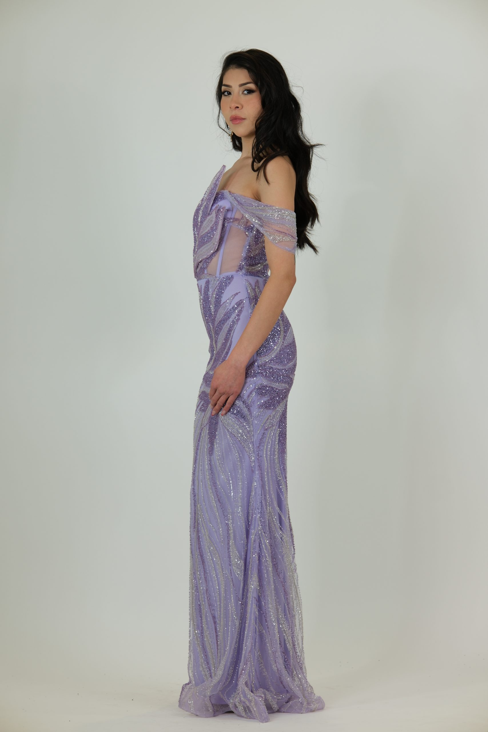 “Lilac sequin evening gown with off-shoulder applique detailing, sheer side panels, fitted skirt, and optional detachable chiffon cape.”