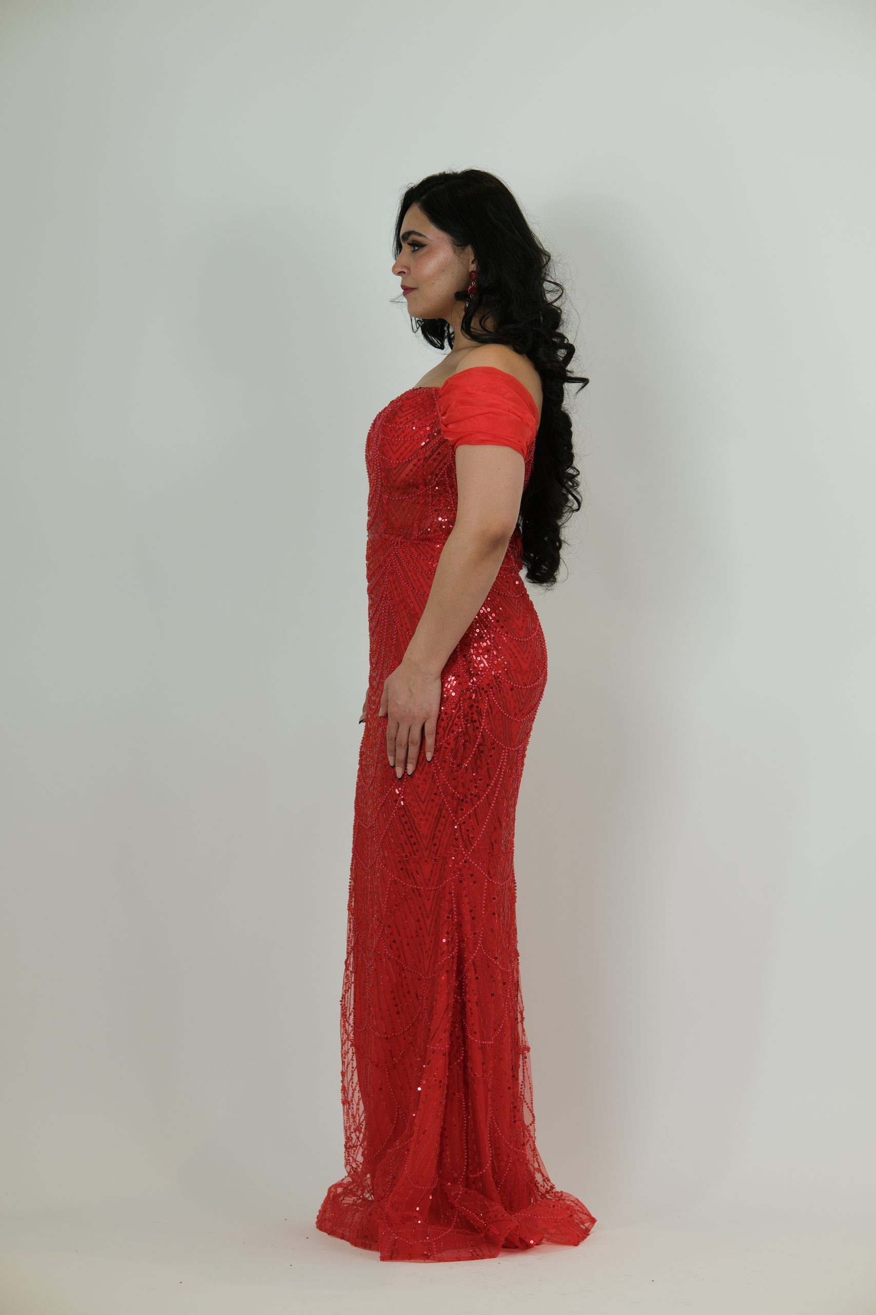 “Red off-the-shoulder beaded gown with sweetheart neckline and detailed sequin pattern.”