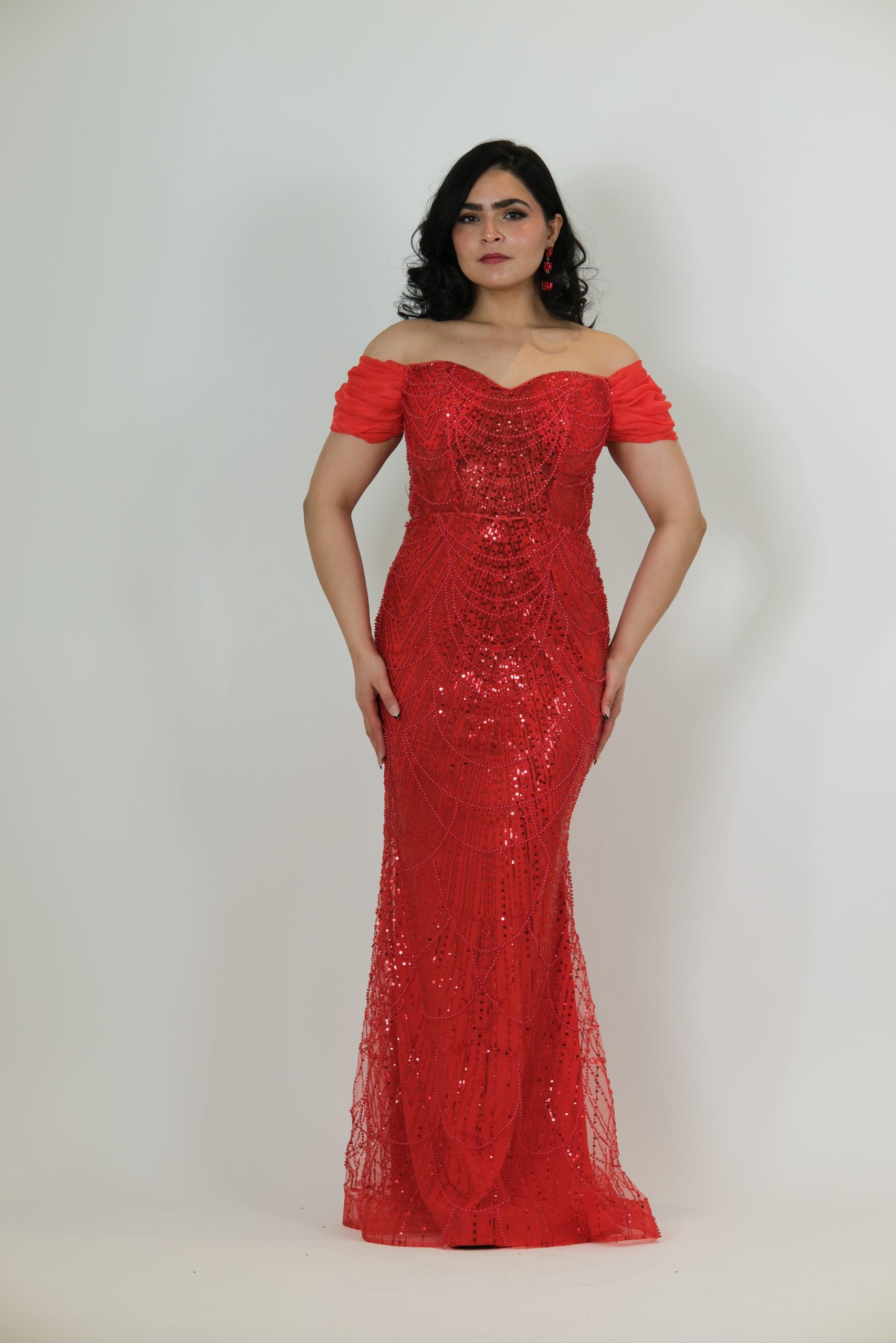 “Red off-the-shoulder beaded gown with sweetheart neckline and detailed sequin pattern.”